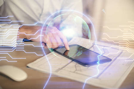 Double exposure of man's hand holding and using a digital device and brain hologram drawing. Data...