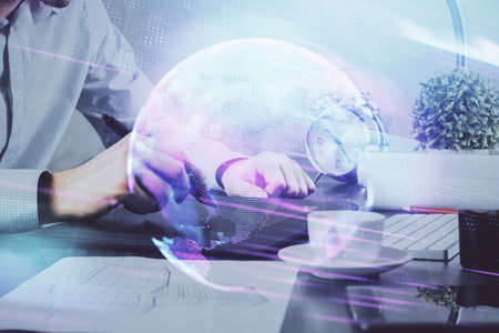 Double exposure of man's hands holding and using a digital device and tech theme hologram drawing....