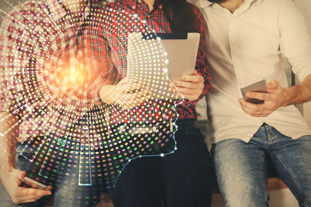Double exposure of man and woman working together holding and using a mobile device and brain...