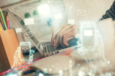 Double exposure of woman hands typing on computer and flying envelop drawing. E-Mail concept.の写真素材