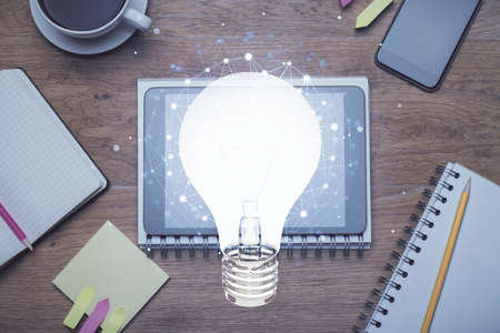 Double exposure of bulb drawing over table with phone. Top view. Concept of idea.の写真素材