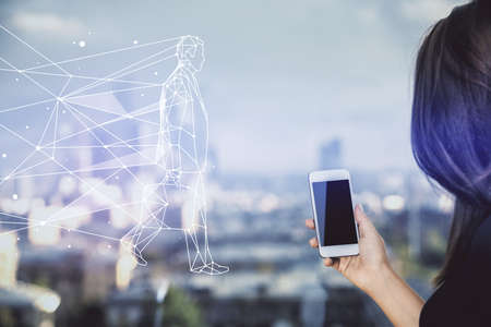Double exposure of creative hologram and woman holding and using a mobile device. Start up concept.