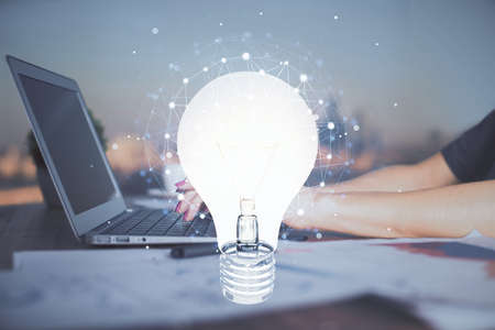 Double exposure of woman hands typing on computer and light bulb drawing. Idea concept.