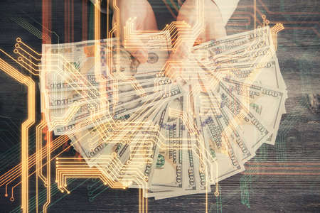 Multi exposure of Tech drawing hologram and USA dollars bills and man hands. Technology concept.の写真素材