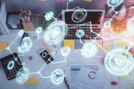 Social network hologram drawings over computer on the desktop background. Top view. Multi exposure....