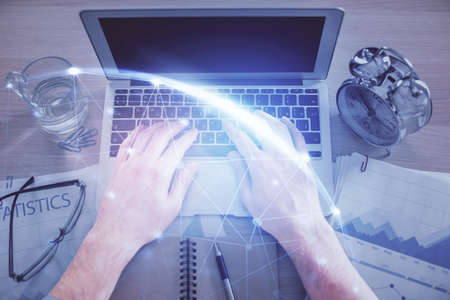 Double exposure of man's hands typing over computer keyboard and social network theme hologram drawing. Top view. People connection web concept.の写真素材