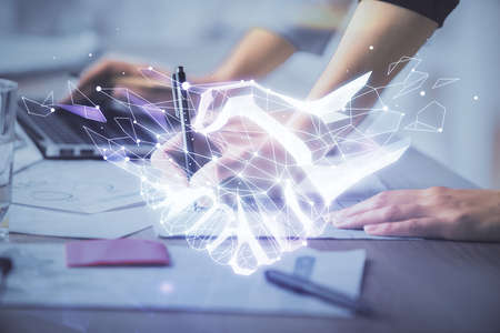 Double exposure of woman hands typing on computer and handshake drawing. Partnership concept.の写真素材