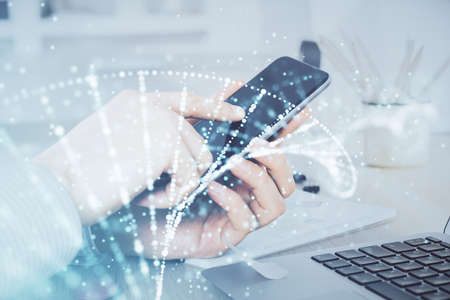 Double exposure of man's hands holding and using a phone and DNA drawing. Medical education concept.