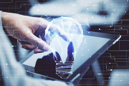 Double exposure of man's hands holding and using a digital device and bulb hologram drawing. Idea concept.の写真素材