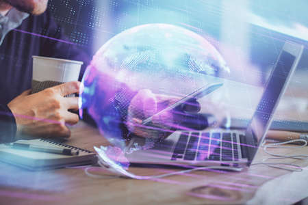 Double exposure of man's hands holding and using a digital device and tech theme hologram drawing. Technology concept.の写真素材