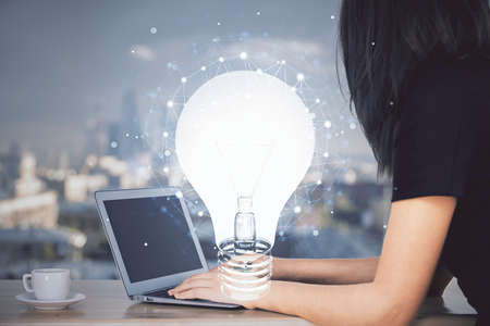 Double exposure of woman hands typing on computer and light bulb drawing. Idea concept.の写真素材