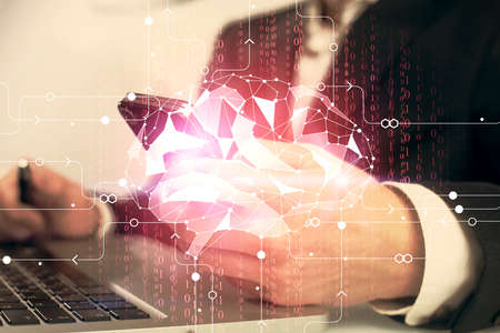 Double exposure of man's hand holding and using a digital device and brain hologram drawing. Data concept.の写真素材
