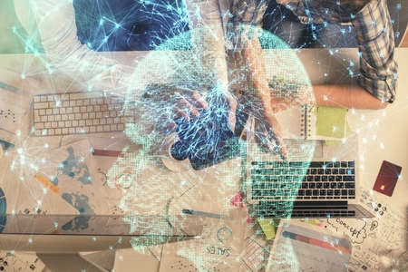 Double exposure of man and woman working together and human brain hologram drawing. Brainstorm concept. Computer background. Top View.の写真素材
