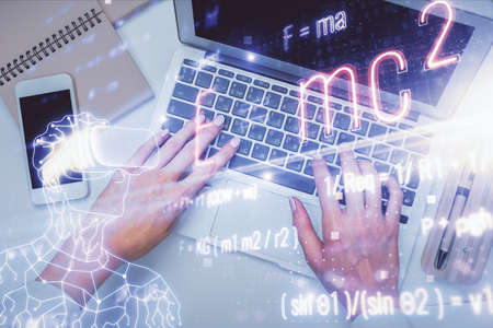 Double exposure of woman hands working on computer and formula hologram drawing. Top View. Science concept.の写真素材
