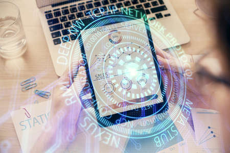 Double exposure of man's hand holding and using a digital device and data theme hologram drawing. Technology concept.の写真素材