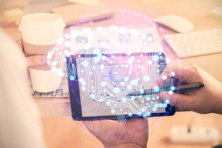 Double exposure of man's hand holding and using a digital device and brain hologram drawing. Data...