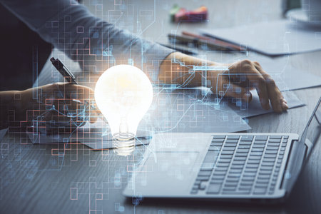 Double exposure of woman hands typing on computer and light bulb drawing. Idea concept.の写真素材