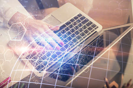 Double exposure of woman hands working on computer and world map hologram drawing. International technology business concept.の写真素材