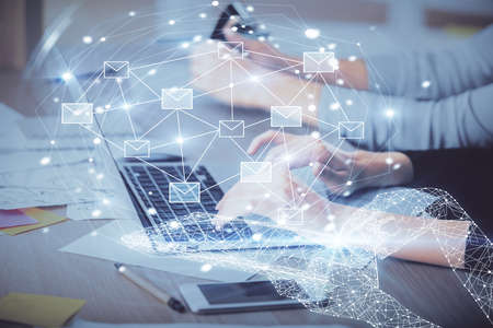 Double exposure of woman hands typing on computer and flying envelop drawing. E-Mail concept.