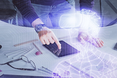 Double exposure of man's hands holding and using a digital device and AR glasses drawing. Virtual...