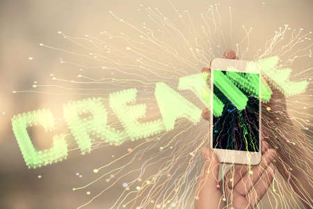 Double exposure of creative hologram and woman holding and using a mobile device. Start up concept.