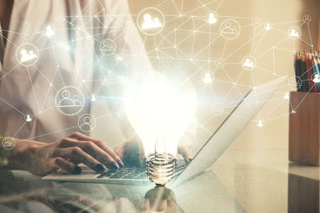 Double exposure of woman hands typing on computer and light bulb drawing. Idea concept.の写真素材