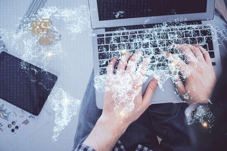 Double exposure of man's hands typing over computer keyboard and social network theme hologram...