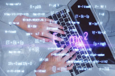 Double exposure of woman hands working on computer and formula hologram drawing. Top View. Science...