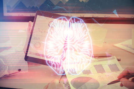 Double exposure of man's hand holding and using a digital device and brain hologram drawing. Data...