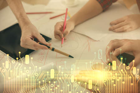 Double exposure of data theme hologram drawing and man and woman working together holding and using a mobile device.の写真素材