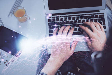 Double exposure of man's hands typing over computer keyboard and social network theme hologram...