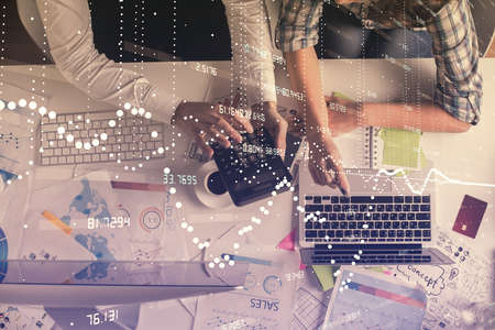 Double exposure of man and woman working together and data theme hologram drawing. Computer background. Top View.の写真素材