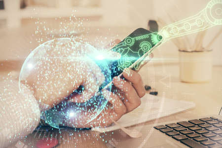 Double exposure of man's hand holding and using a digital device and data theme hologram drawing....