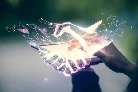 Double exposure of handshake hologram and woman holding and using a mobile device. Partnership concept.の写真素材