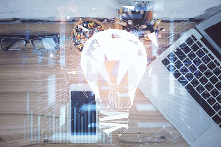 Double exposure of bulb drawing over table with phone. Top view. Concept of idea.の写真素材