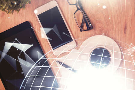 Double exposure of map hologram drawing over desktop. Top view. International connection concept.の写真素材