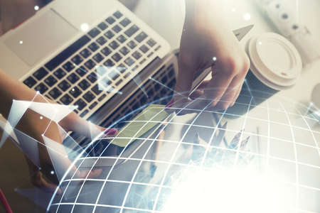Double exposure of woman hands working on computer and world map hologram drawing. International...