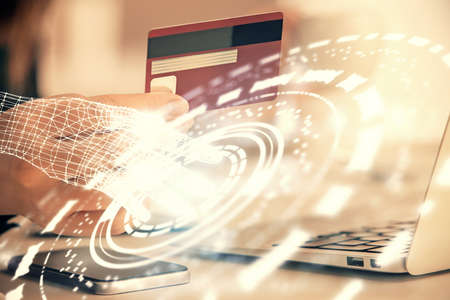 Double exposure of woman on-line shopping holding a credit card and data theme hologram drawing. E-commerce concept.の写真素材