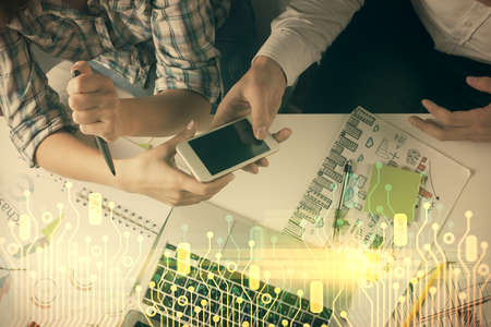 Double exposure of data theme hologram drawing and man and woman working together holding and using...