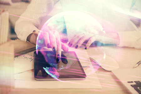 Double exposure of tech icon hologram and woman holding and using a mobile device. Technology concept.の写真素材