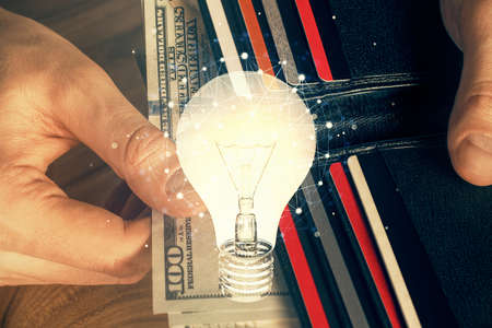 Multi exposure of bulb drawing hologram and USA dollars bills and man hands. Business Idea concept.