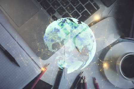 Social network hologram drawings over computer on the desktop background. Top view. Multi exposure....