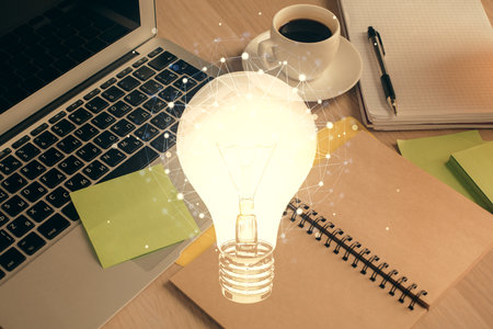 Double exposure of bulb drawing and desktop with coffee and items on table background. Concept of ideas.の写真素材