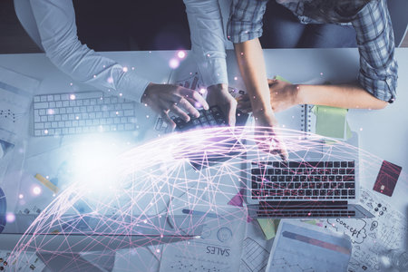 Double exposure of man and woman working together and social network theme hologram drawing. Computer background. connecting concept. Top View.の写真素材