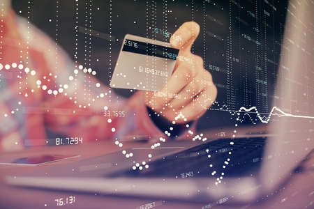 Double exposure of man hands holding a credit card and data theme drawing. E-commerce and technology concept.の写真素材