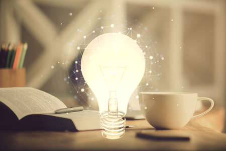 Double exposure of bulb drawing and desktop with coffee and items on table background. Concept of...