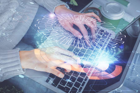 Double exposure of woman hands working on computer and data theme hologram drawing. Tech concept.の写真素材