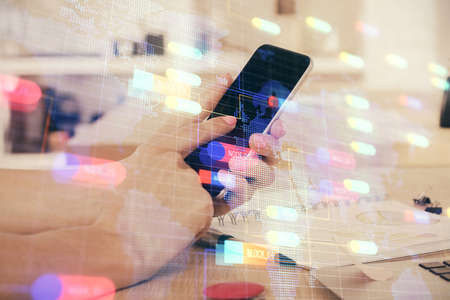 Double exposure of man's hand holding and using a digital device and data theme drawing. Technology...