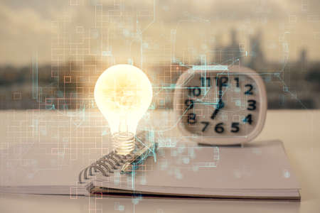 Double exposure of bulb drawing and desk with open notebook background. Concept of ideaの写真素材