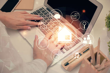 Double exposure of woman hands typing on computer and buildings drawing. Smart-city concept.の写真素材